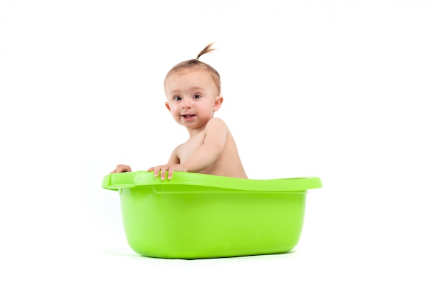 Happy cute baby girl take bath in green tub