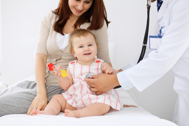 Happy cute baby with her mother at health exam at doctor's office