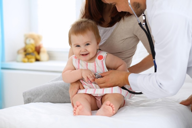 Happy cute baby with her mother at health exam at doctor's office