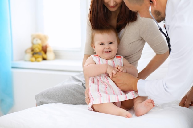 医者のオフィスでの健康診断で彼女の母親と一緒に幸せなかわいい赤ちゃん