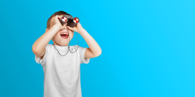 a happy cute boy is having looking through binoculars