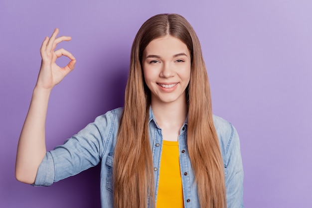 Photo happy cute girl showing ok gesture toothy smile on violet background