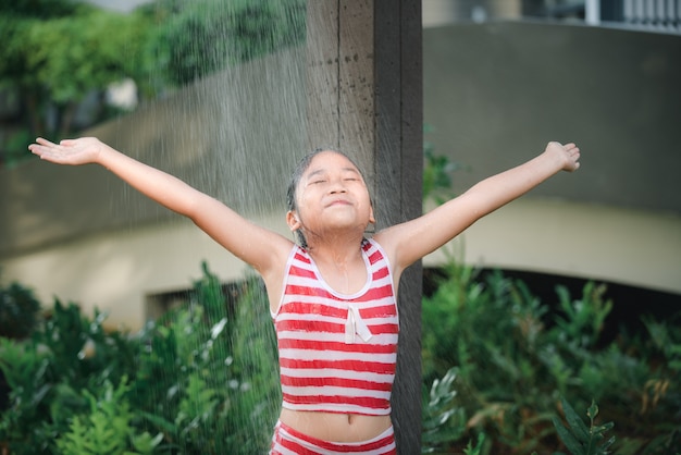 Happy cute girl taking shower before swimming,