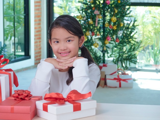 Happy cute girl with gift boxes at home with festive decorations.