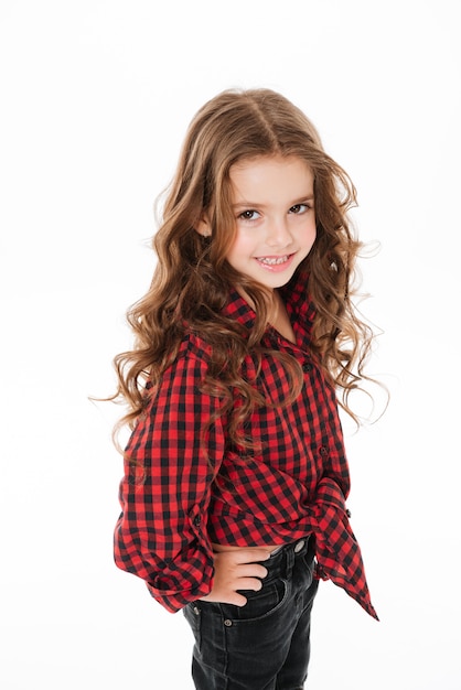 Happy cute little girl in plaid shirt standing and posing