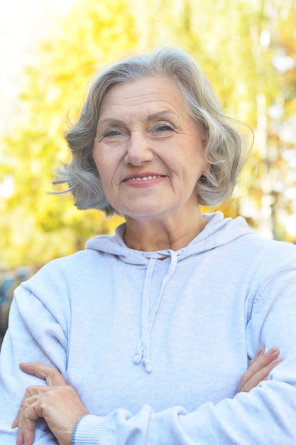 Happy cute senior woman in autumn park