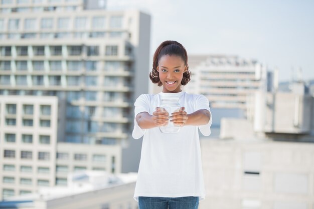 Happy cute volunteer holding glass jar