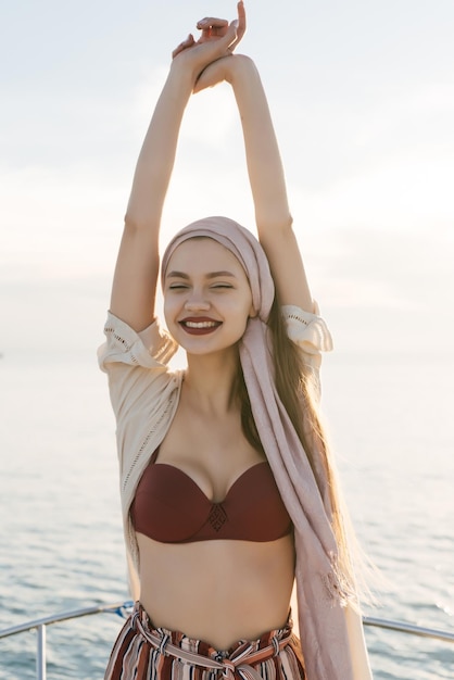 Happy cute young girl enjoys relaxing on a yacht smiling and posing