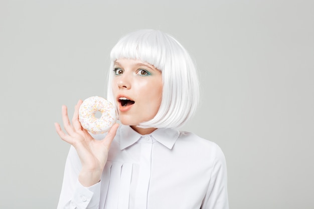 Happy cute young woman holding sweet donut