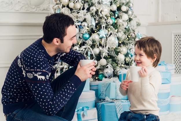 写真 クリスマスにお茶を飲みながら幸せなお父さんと息子