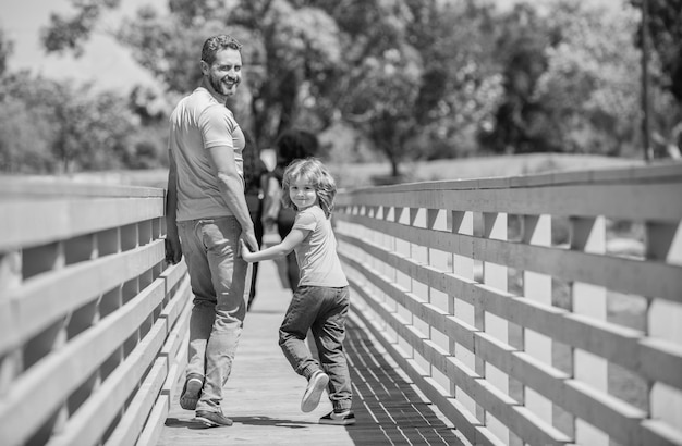 Happy dad having fun with his son walking outdoor parenthood
