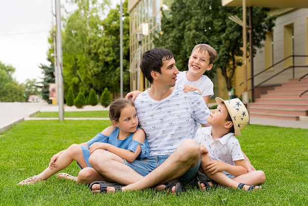 Happy dad and his children on the green lawn. children's day