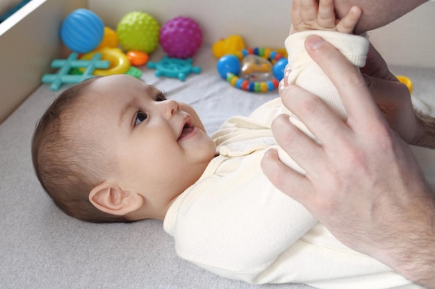 Happy dad and son having fun at home Father and baby boy in bedroom on a bright background Tenderness parenthood