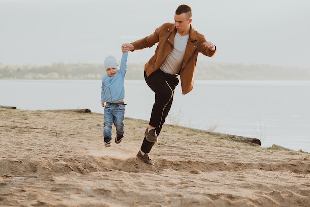 Papà felice e figlio che giocano su una spiaggia