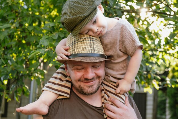 Happy dad and toddler son spending time together outdoors enjoying summer