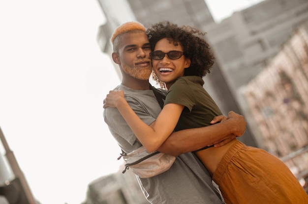 A happy dark-skinned couple in the street looking excited