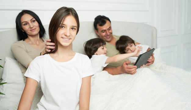 Happy daughter. Portrait of pretty teenage latin girl smiling at camera while spending time with her family in the morning. Parenthood, children concept