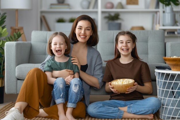 Happy day Mom and her daughters children girls are playing smiling and hugging