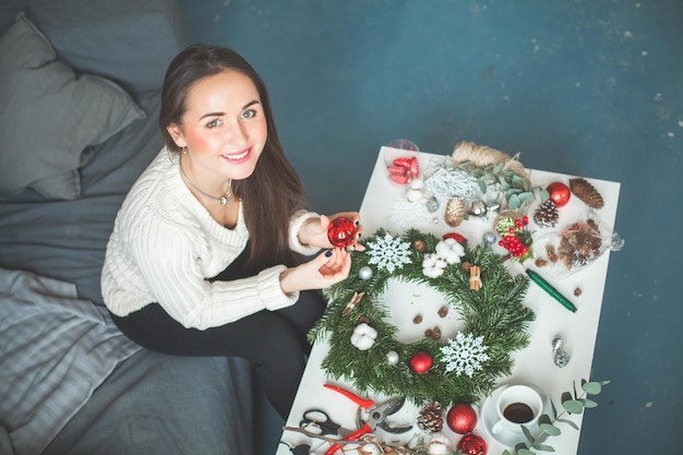 クリスマスの飾りを作る幸せなデコレータまたは花屋の女性