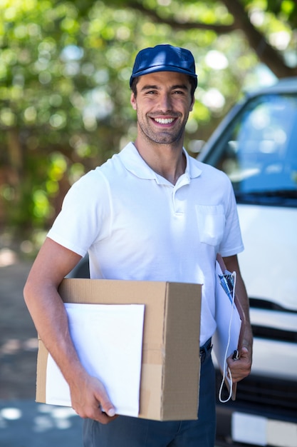 Happy delivery person with cardboard box 