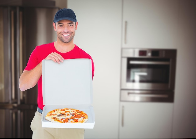 Happy deliveryman showing the pizza in the kitchen