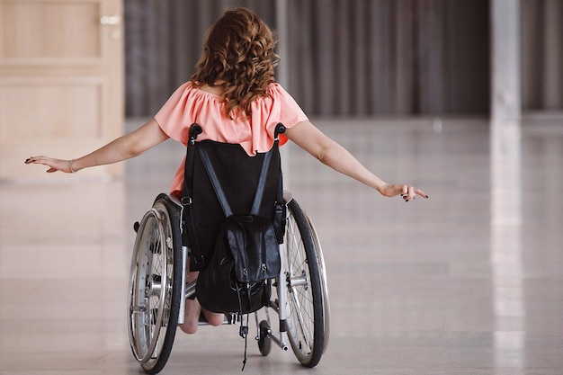 Felice donna disabile su una sedia a rotelle indietro