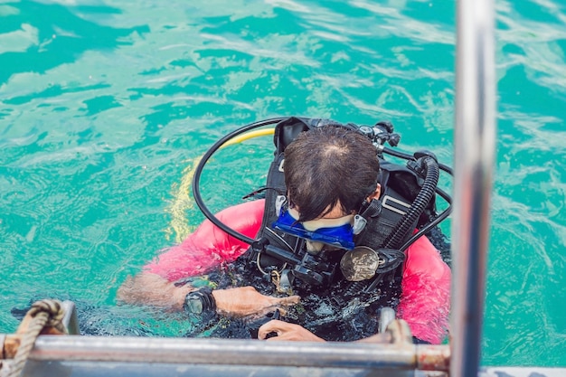 Happy diver returns to the ship after diving