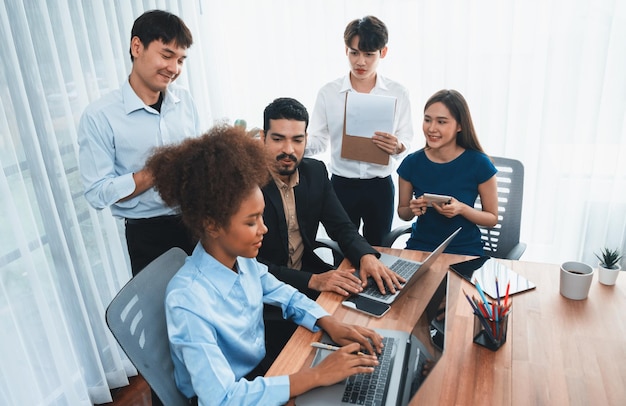 Happy diverse business people work together discussing in corporate office Professional and diversity teamwork discuss business plan on desk with laptop Modern multicultural office worker Concord