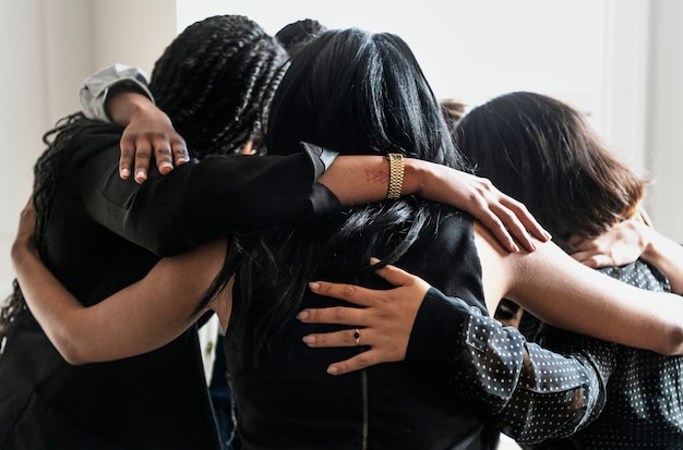 Happy diverse businesswomen huddling in the office