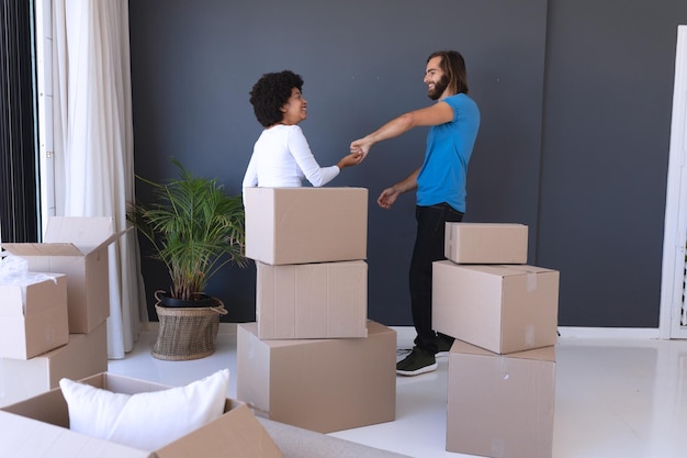 Happy diverse couple moving house smiling and dancing