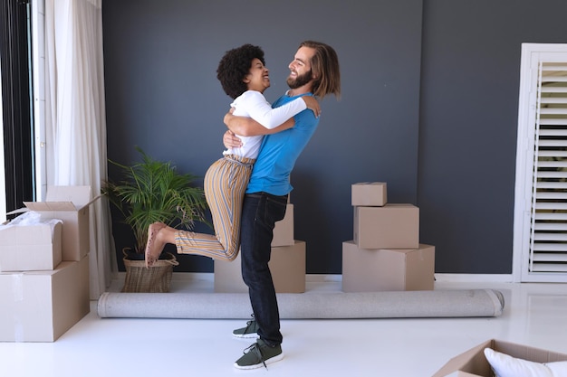 Happy diverse couple moving house smiling and dancing