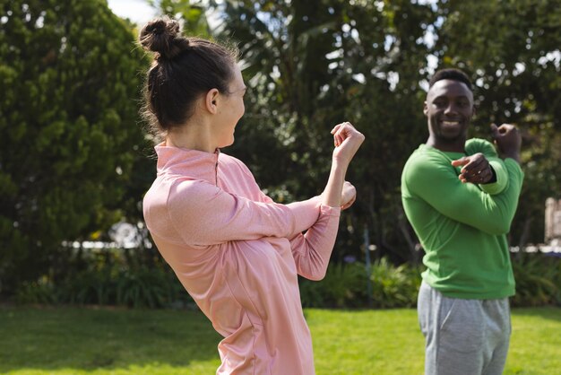 Photo happy diverse couple practicing yoga and stretching in garden