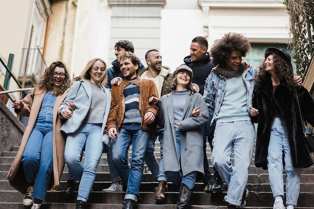 Happy diverse friends having fun walking around the city - Focus on center girl face