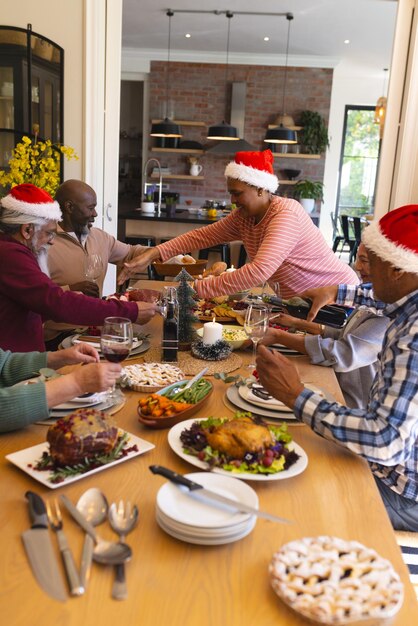 Photo happy diverse group of senior friends celebrating at christmas dinner in sunny dining room at home