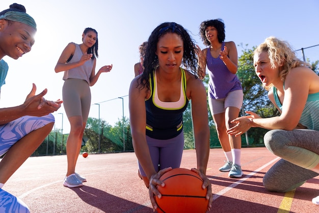 happy diverse group of women doing push ups with basketball and cheering at basketball court. sport, activity, motivation, togetherness and lifestyle, unaltered.