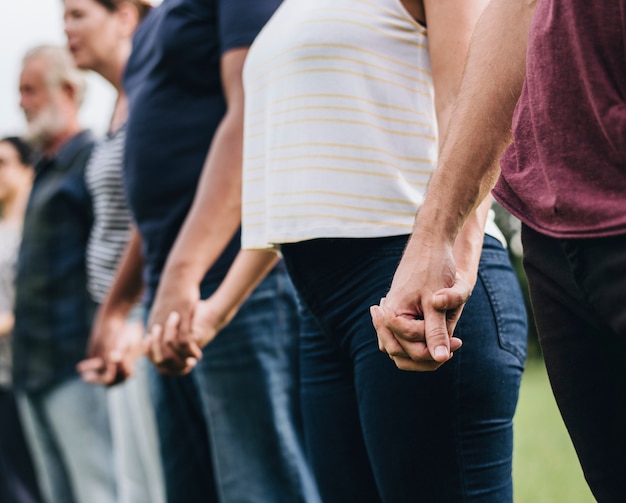 Happy diverse people holding hands in the park