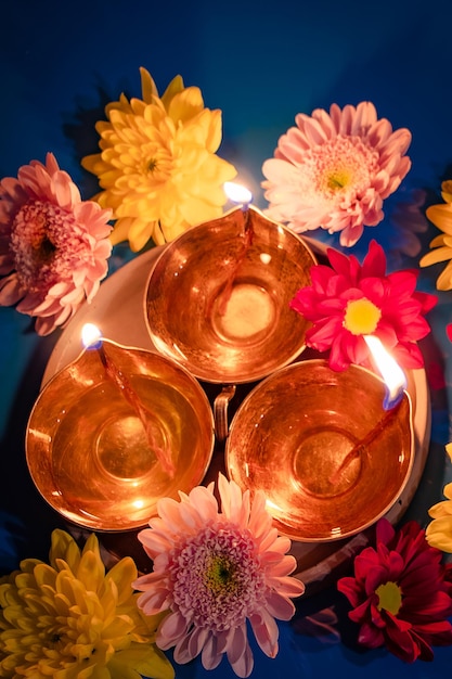 Happy Diwali Celebrating the Hindu Light Festival Traditional diya oil lamps and flowers on blue background