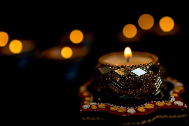 Happy Diwali Clay Diya lamps lit during Dipavali Hindu festival of lights celebration Colorful traditional oil lamp diya on dark background Copy space for text