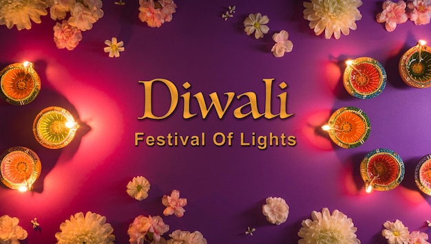 Happy Diwali Clay Diya lamps lit during Dipavali Hindu festival of lights celebration Colorful traditional oil lamp diya and flowers on purple background