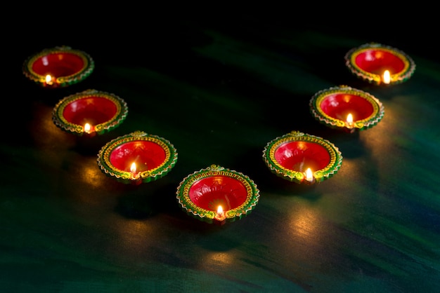 Счастливого Дивали - глина Дия лампы зажглись во время празднования Дивали. Приветствие Дизайн индийского индуистского фестиваля света под названием Дивали