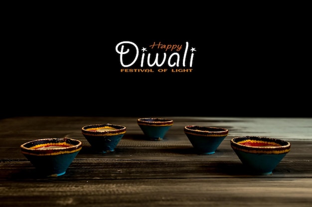 Photo happy diwali clay diya lamps lit during dipavali hindu festival of lights celebration colorful traditional oil lamp diya on dark background copy space for text