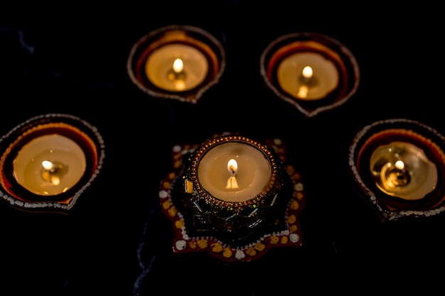 Foto happy diwali clay diya lampade accese durante la celebrazione delle luci indù dipavali lampada a olio tradizionale colorata diya su sfondo scuro copia spazio per il testo