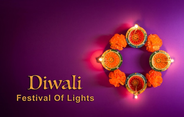 Photo happy diwali clay diya lamps lit during dipavali hindu festival of lights celebration colorful traditional oil lamp diya on purple background