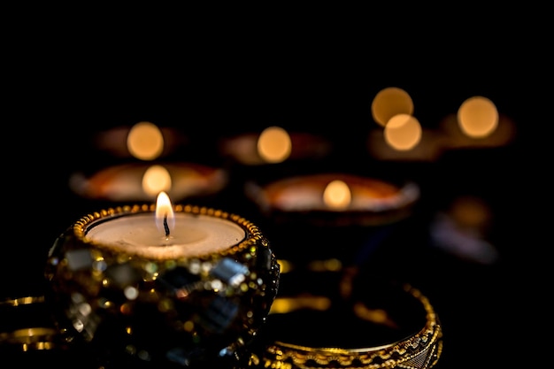 写真 ディパバリ ヒンズー教の光の祭典中にハッピー ディワリ粘土ディヤ ランプが点灯暗い背景にカラフルな伝統的なオイル ランプ ディヤ テキスト用のスペースをコピーします