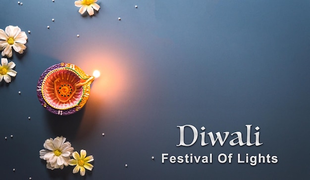 Фото Лампы happy diwali clay diya зажжены во время празднования дивали индуистского фестиваля огней красочная традиционная масляная лампа diya на синем фоне
