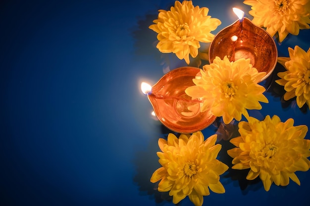 Счастливые масляные лампы дивали дия и желтые цветы на синем фоне празднование традиционного индийского праздника света