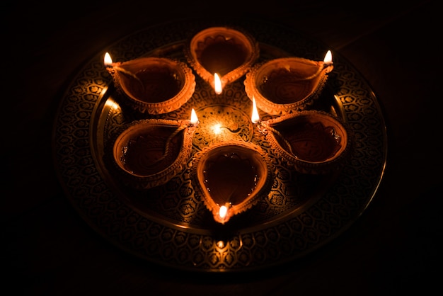 Happy Diwali - veel Terracotta diya of olielampen gerangschikt over kleioppervlak of grond in één lijn of gebogen of zigzagvorm, selectieve focus