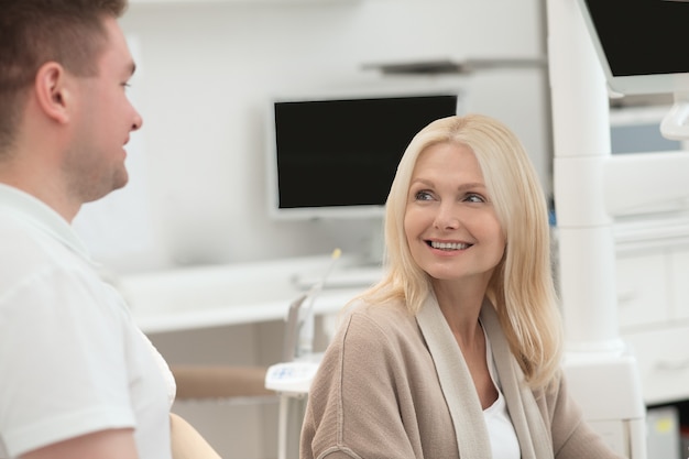 Photo happy doctor and his patient after the dental surgery