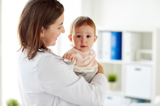 Photo happy doctor or pediatrician with baby at clinic