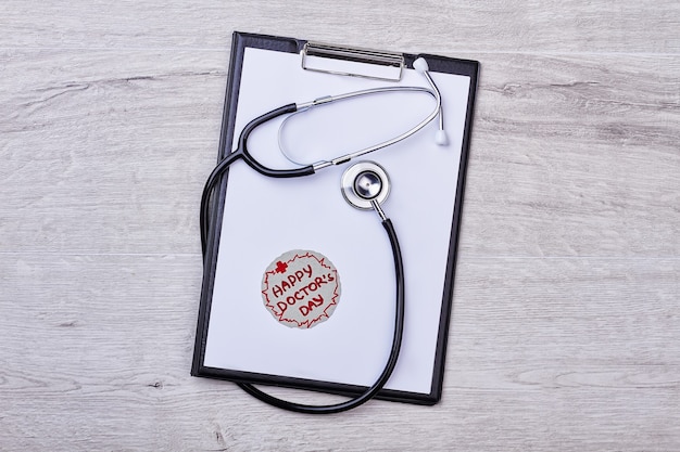 Happy Doctor's Day card. Clipboard with stethoscope. Thank your doctor.